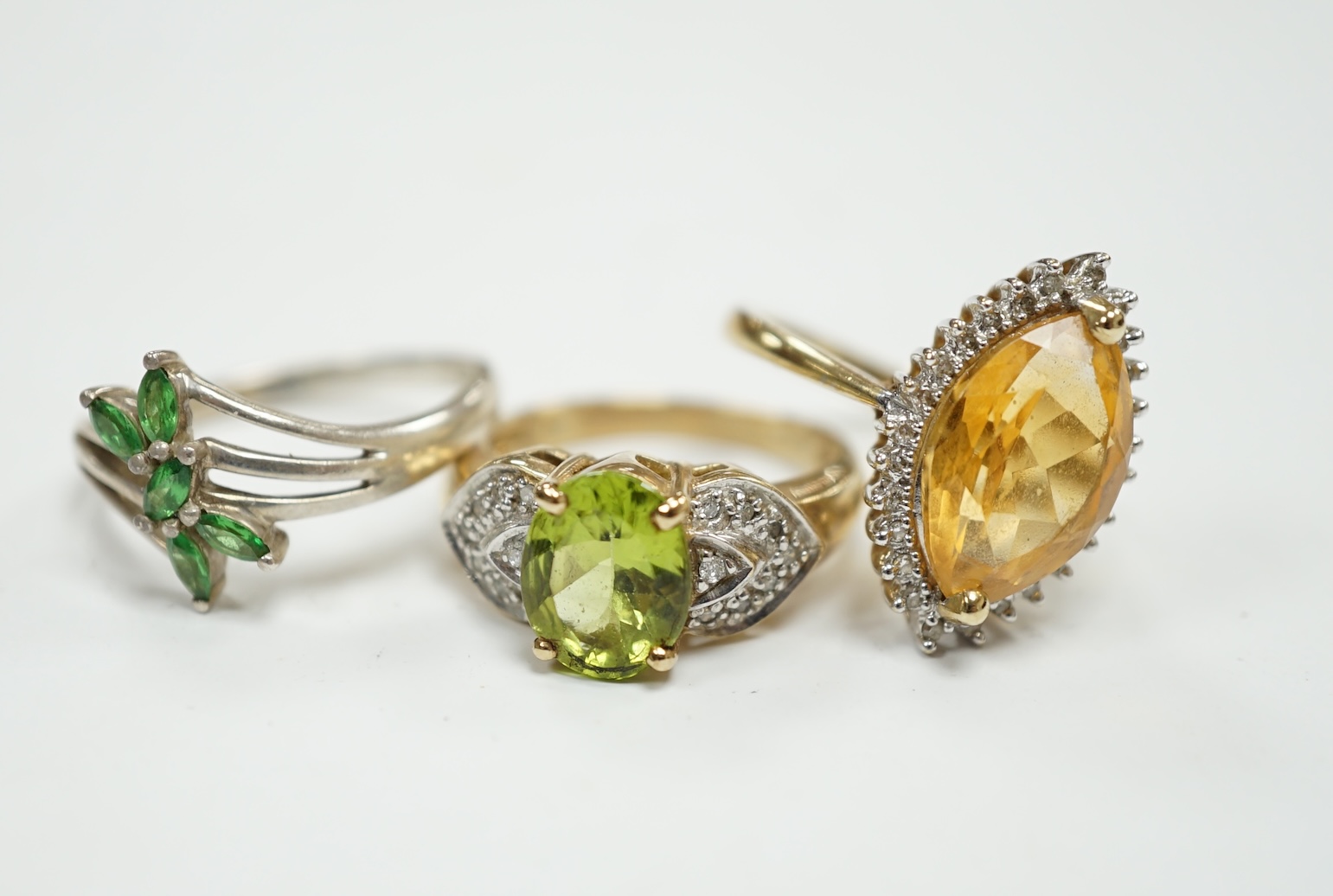 Two modern 9ct gold and gem set dress rings, including citrine and diamond chip and peridot and diamond chip, gross weight 8.2 grams, together with a 925 ring. Condition - fair to good